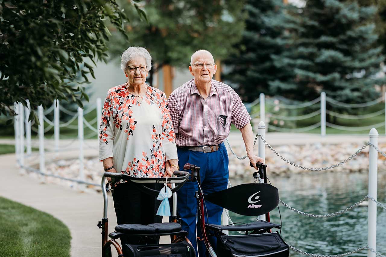 the wellington retirement residence happy seniors strolling outside pond