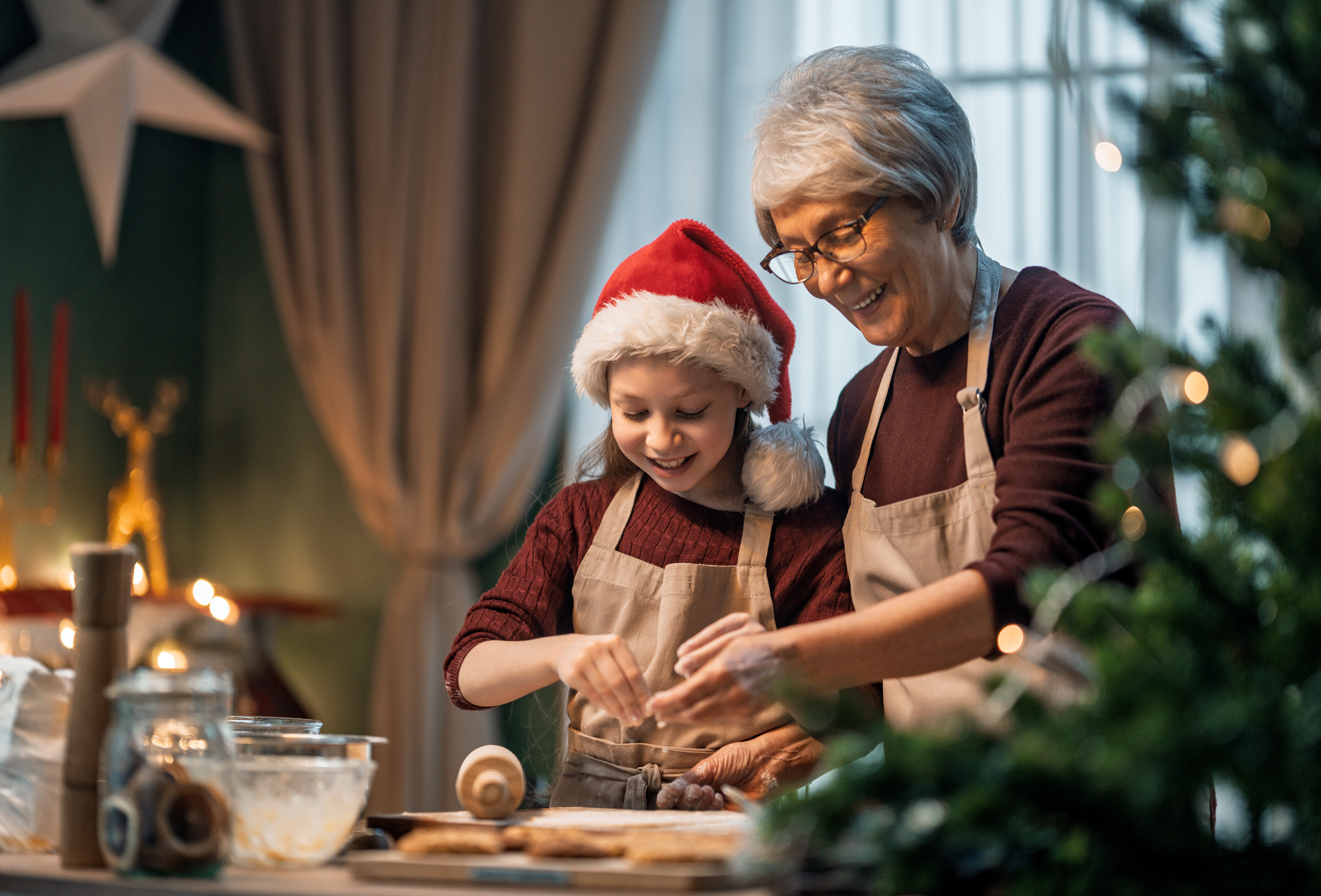 A senior woman makes christmas cookies with her grandaughter