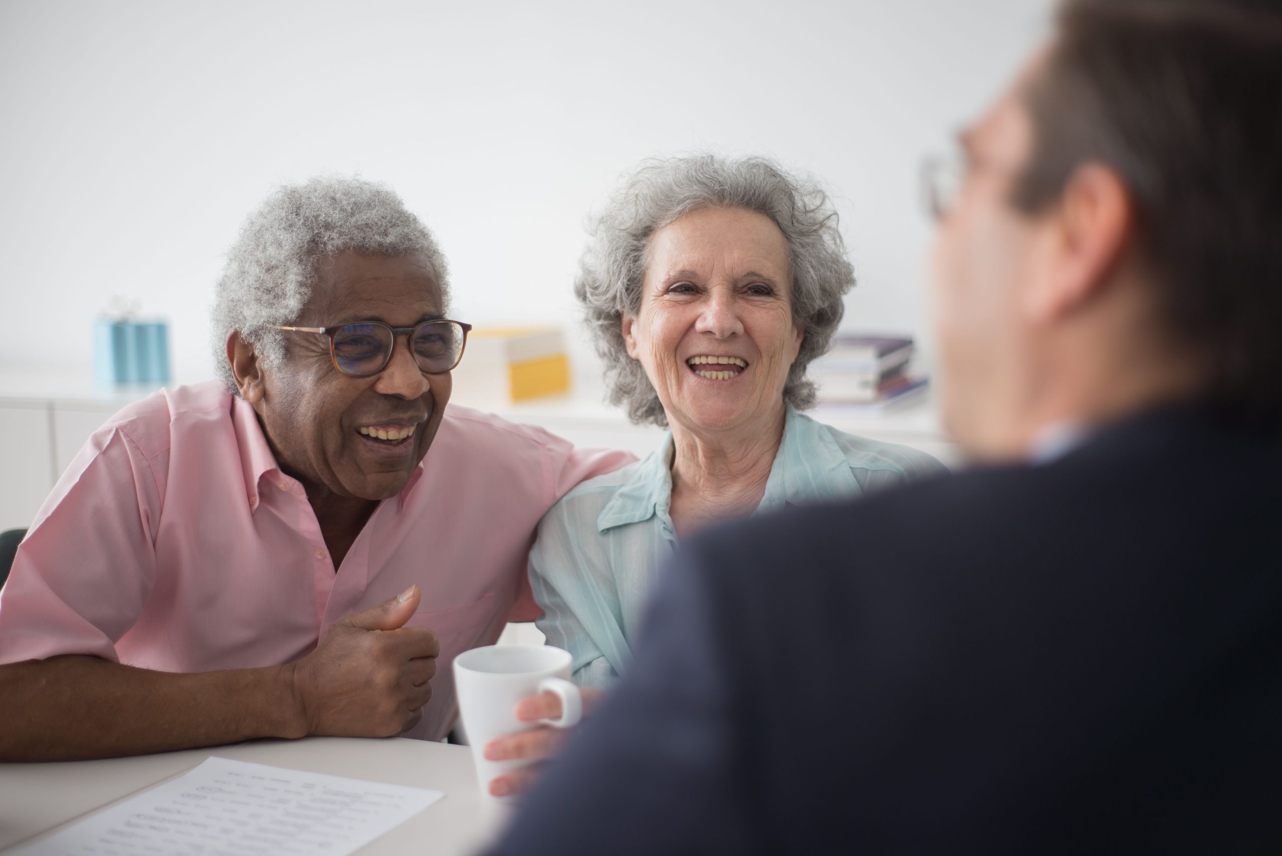 two seniors drinking coffee smiling