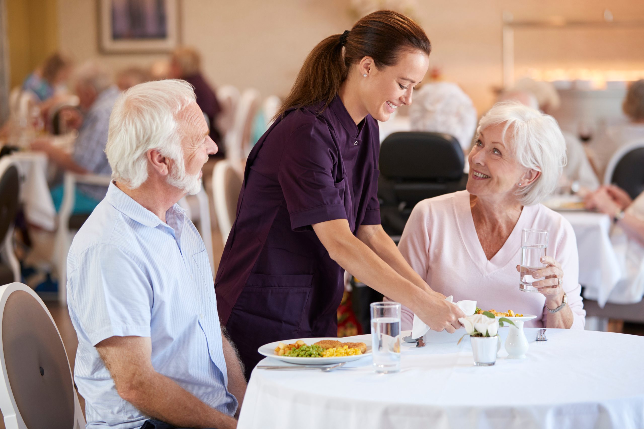 two seniors eating in a dining hall